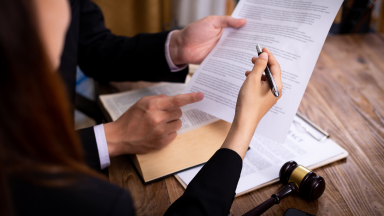 A team of attorneys looks through paperwork together.
